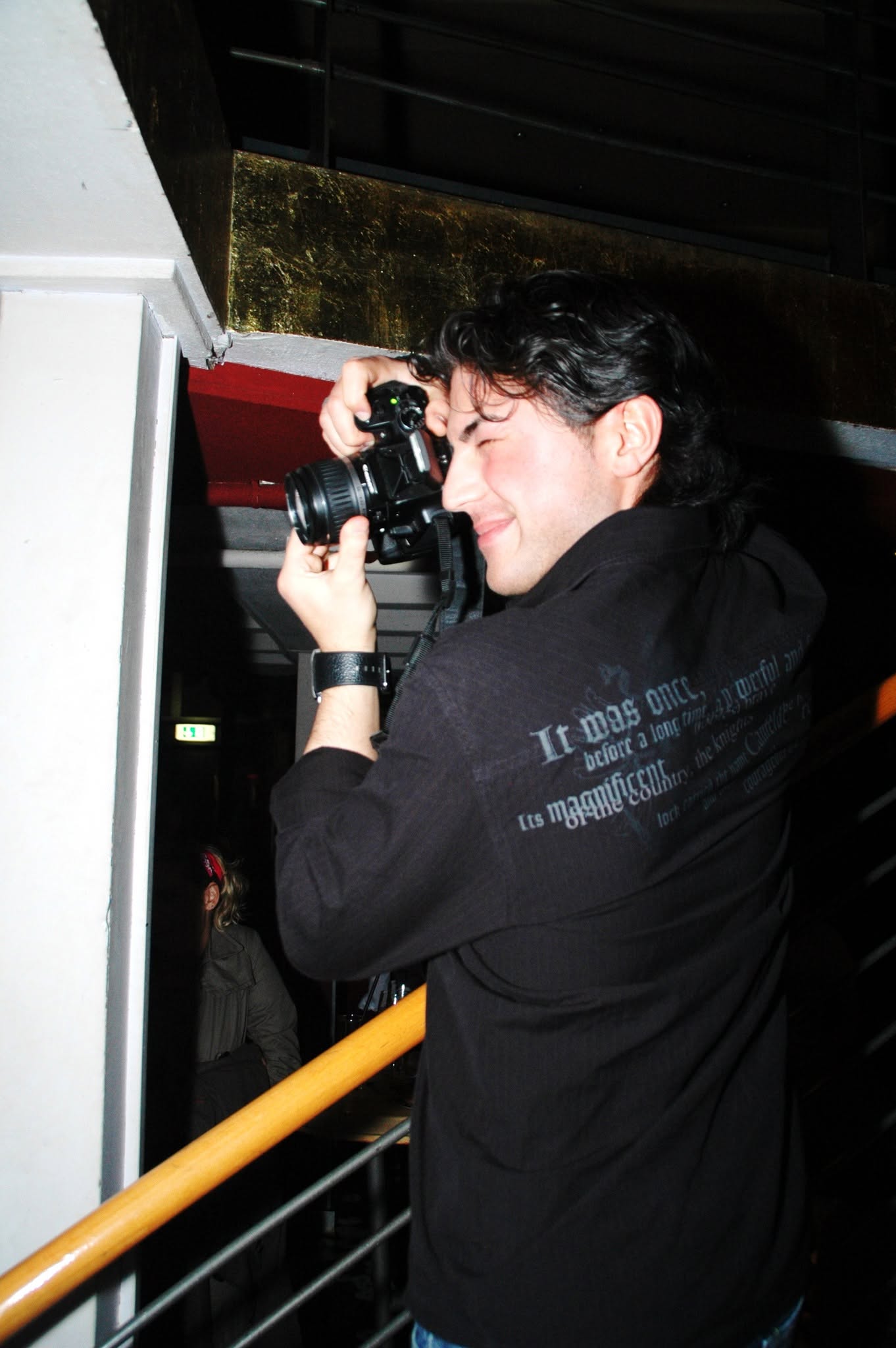 Ein Fotograf hält seine Kamera vor dem Gesicht.