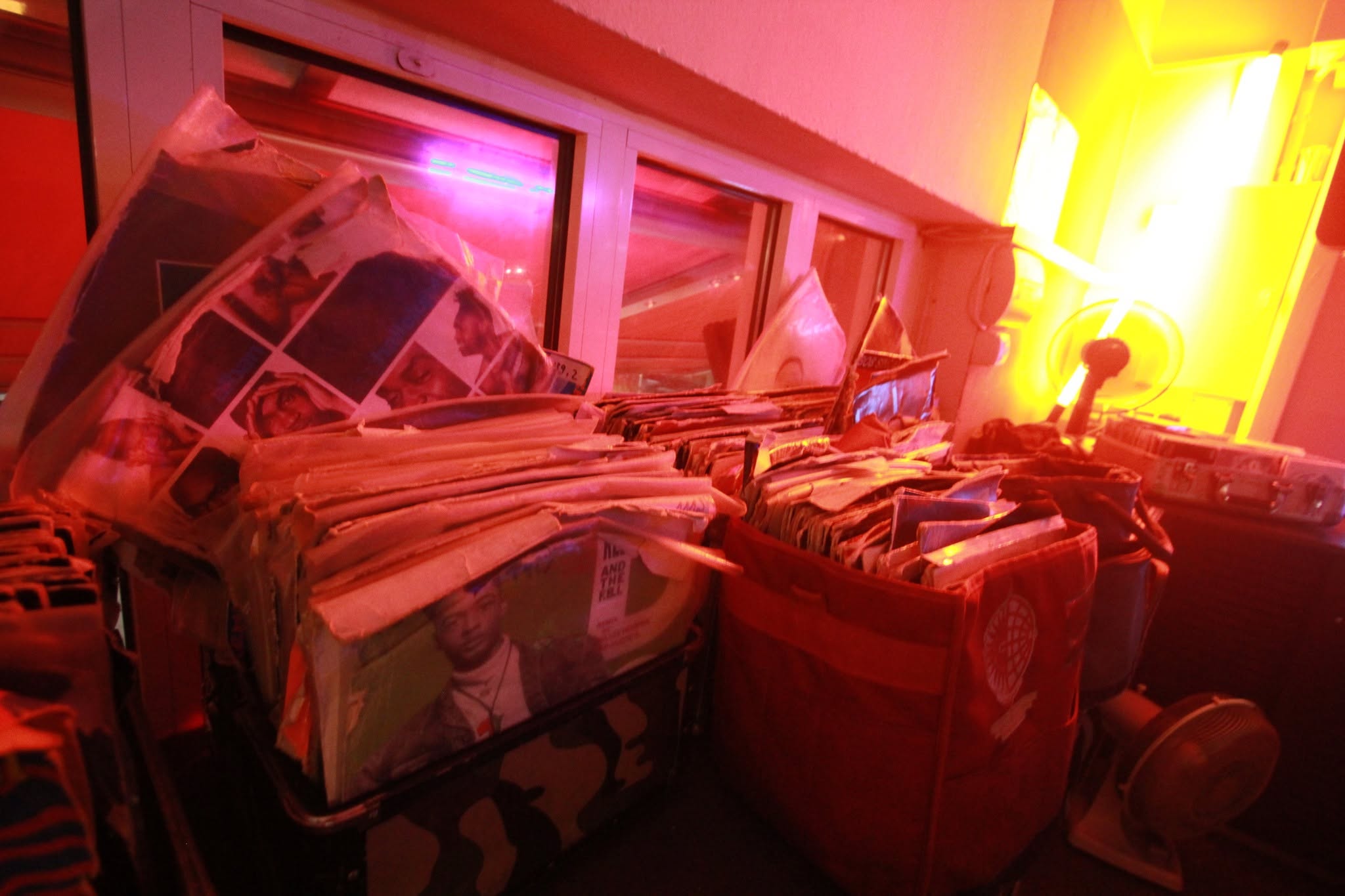 Schallplattenkisten im warm beleuchteten DJ-Bereich.