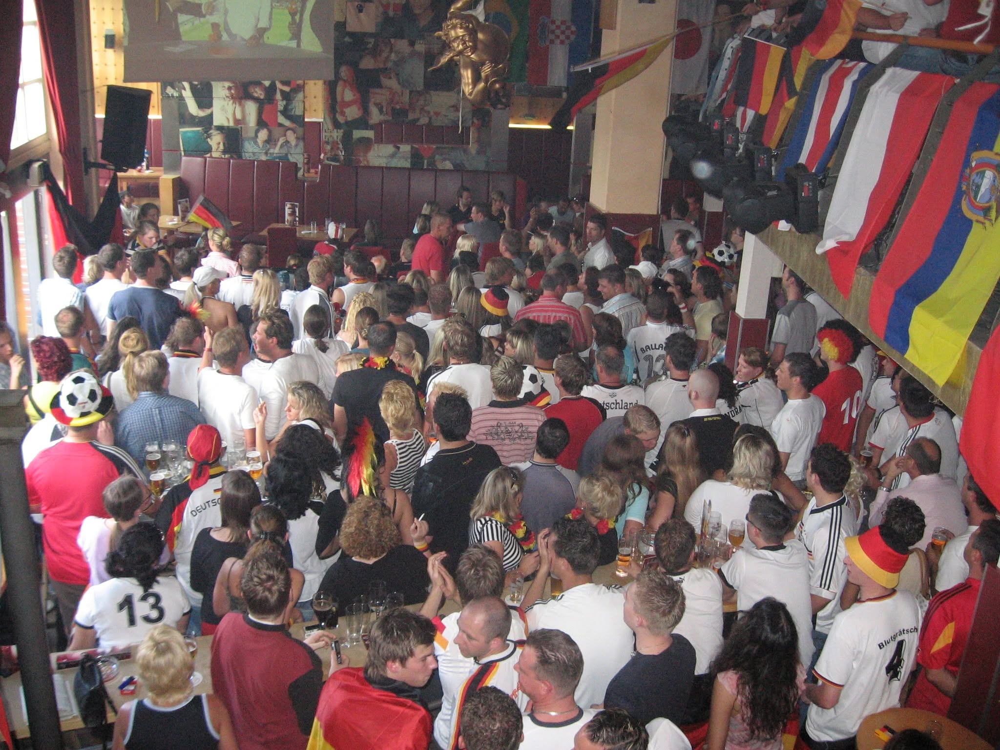Blick von oben auf zahlreiche Gäste unter Länderflaggen.
