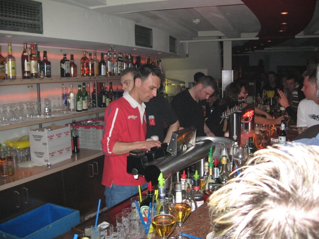 Betrieb hinter der Bar zwischen Flaschen und Gläsern.