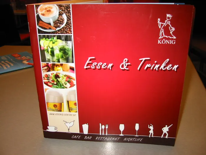 Rote KÖNIG-Speisekarte mit Essensfotos und der Aufschrift Essen und Trinken.